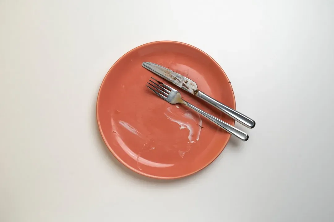 흰 바탕에 놓인 접시와 포크·나이프를 위에서 내려다본 정물. 식사를 마치고 비워진 접시로, 내시경 전 금식과 위를 비우는 준비를 나타낸다